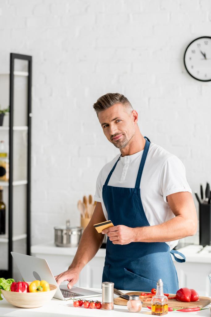 adult man doing shopping online on laptop at kitchen - Photo, Image