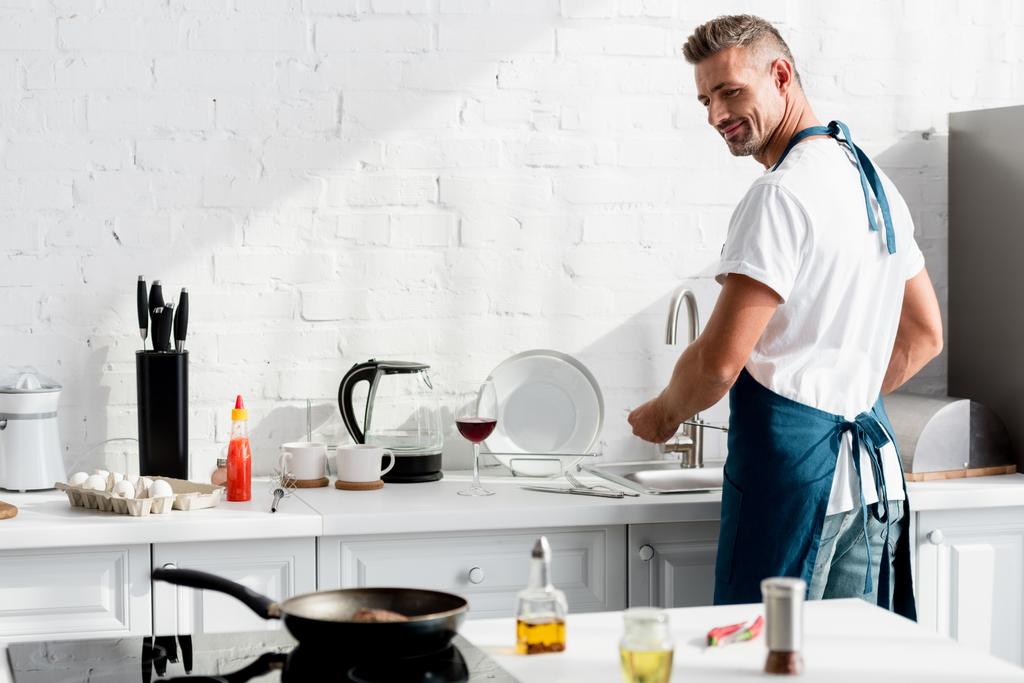 adult man washing dishes at kitchen - Photo, Image
