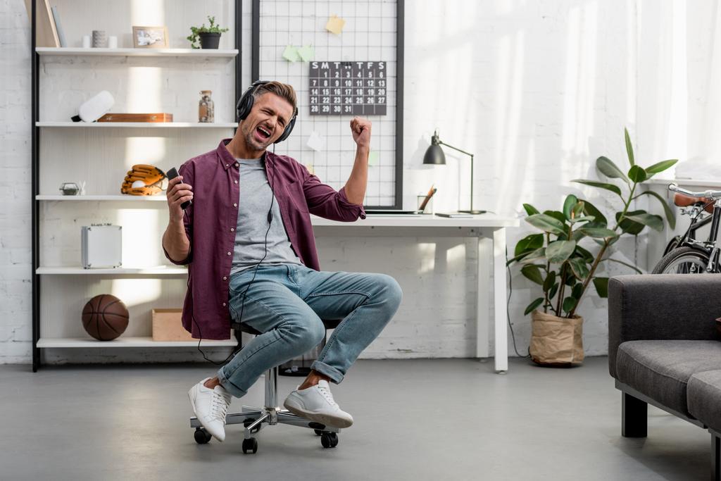 boldog ember, zene és ének ülve szék otthoni irodai - Fotó, kép
