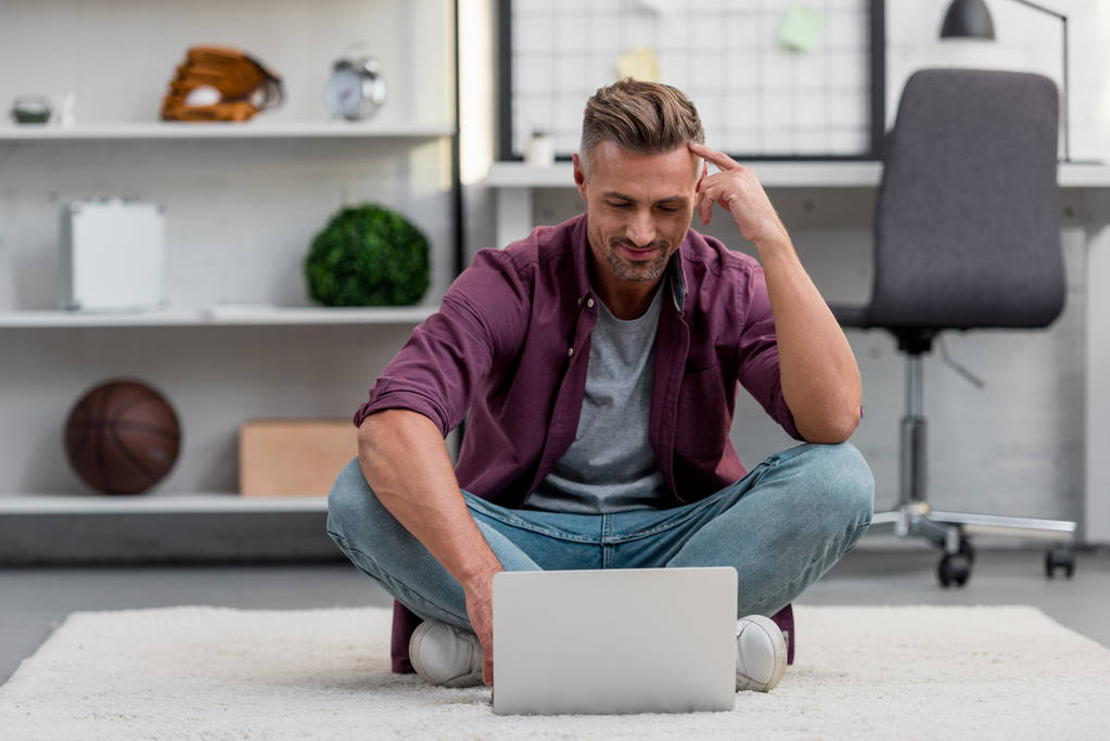 przystojny mężczyzna siedzi w domu i pracy na laptopie - Zdjęcie, obraz