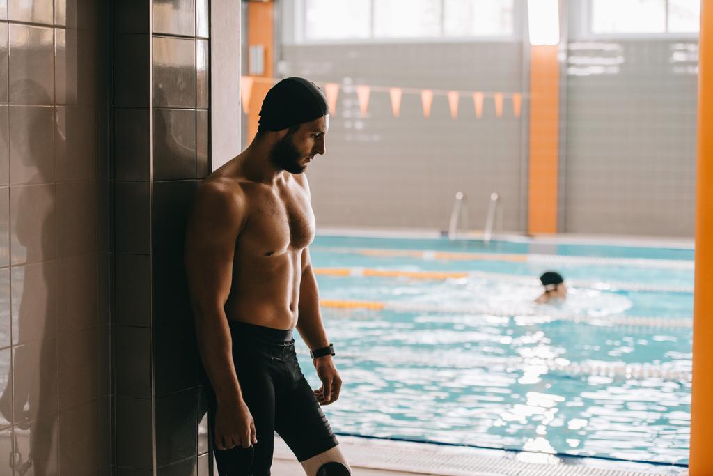 beau nageur avec jambe artificielle debout au bord de la piscine intérieure
 - Photo, image