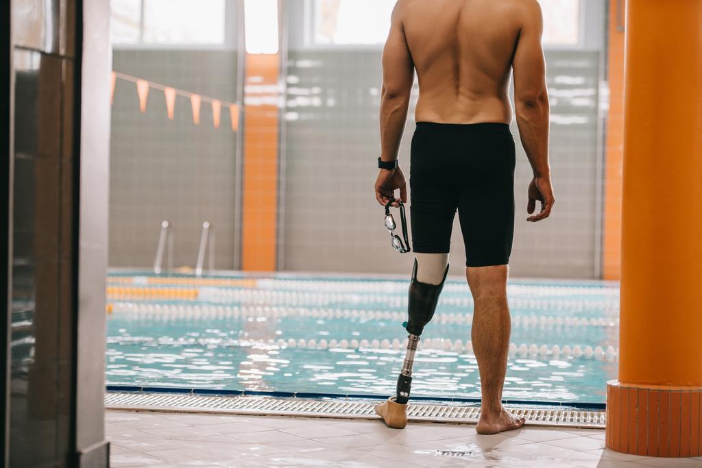 Schnappschuss von Sportler mit Beinprothese vor Hallenbad - Foto, Bild