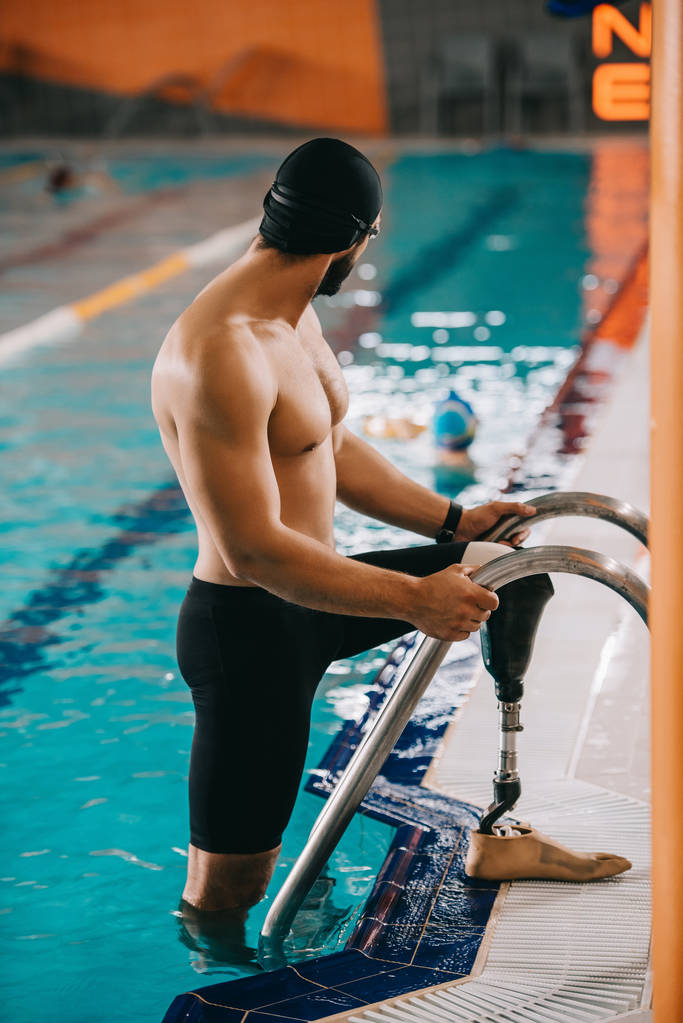 joven nadador musculoso con pierna artificial saliendo de la piscina
 - Foto, imagen