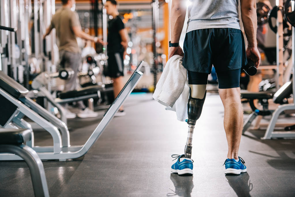 plan recadré d'un sportif avec une jambe artificielle debout au gymnase et tenant une serviette
 - Photo, image