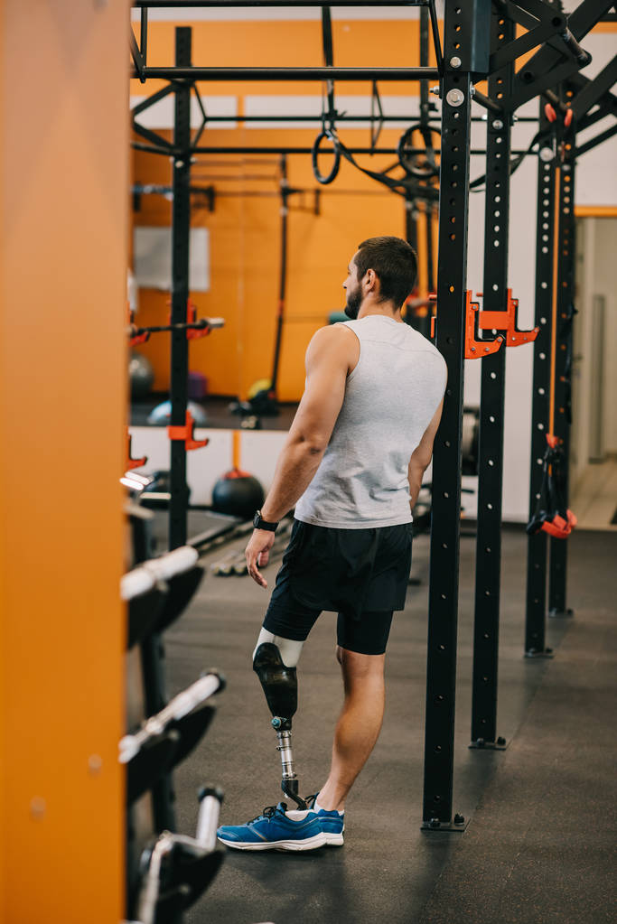 atlético jovem desportista com perna artificial em pé perto de escada de ginástica no ginásio
 - Foto, Imagem