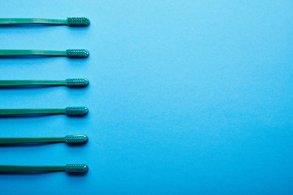 tasainen lay kanssa hammasharjat järjestetty sininen tausta
 - Valokuva, kuva
