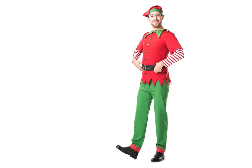 sonriente hombre en traje de elfo de Navidad mirando a la cámara con las manos en las caderas aisladas en blanco
 - Foto, imagen