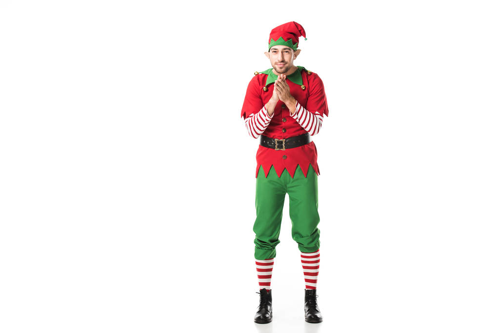 hombre excitado en traje de elfo de Navidad mirando a la cámara y frotándose las manos en anticipación aislado en blanco
 - Foto, Imagen