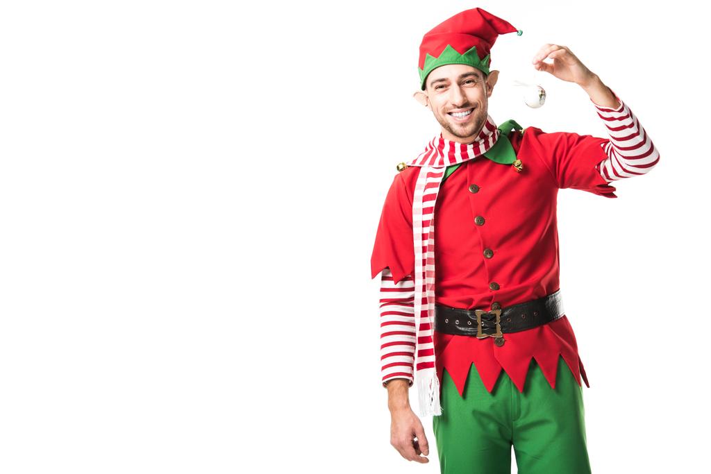 άνθρωπος στο κοστούμι elf Χριστουγέννων κρατώντας μπιχλιμπίδι, χαμογελούν και βλέπουν τα φωτογραφικών μηχανών που απομονώνονται σε λευκό - Φωτογραφία, εικόνα