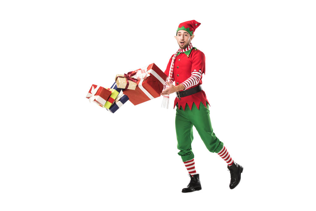 verrast man in kerst elf kostuum per ongeluk vallen stapel presenteert geïsoleerd op wit - Foto, afbeelding