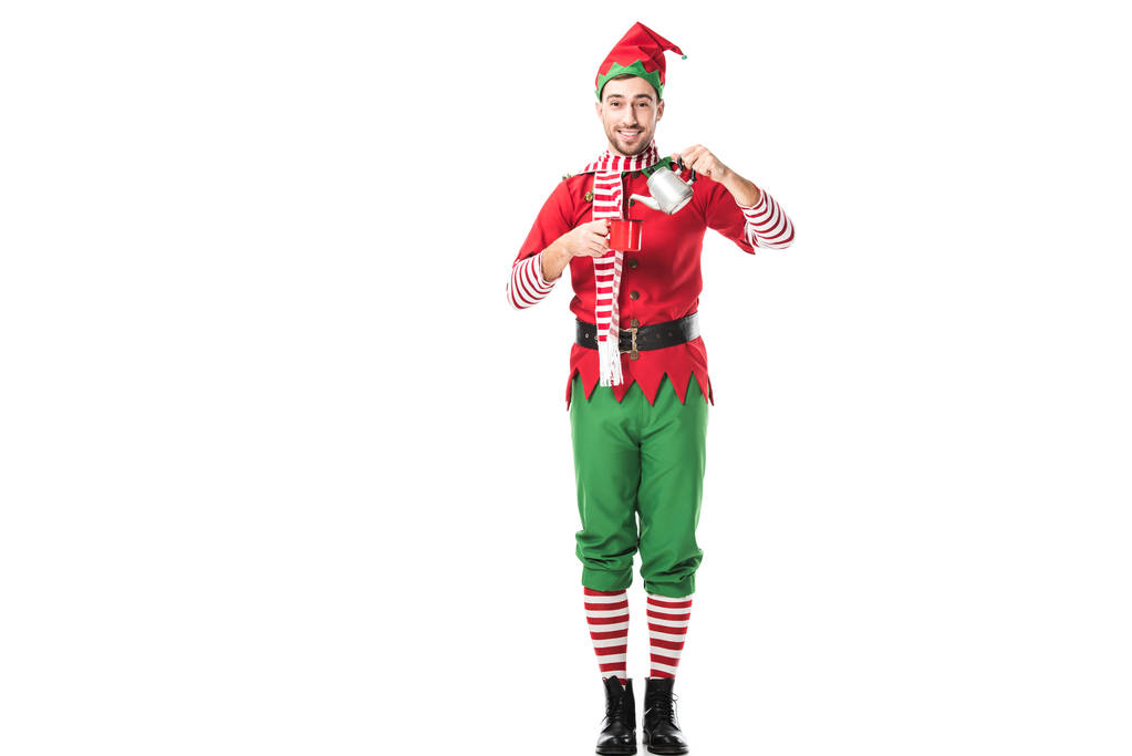 homme heureux en costume d'elfe de Noël tenant tasse rouge et bouilloire en métal isolé sur blanc
 - Photo, image
