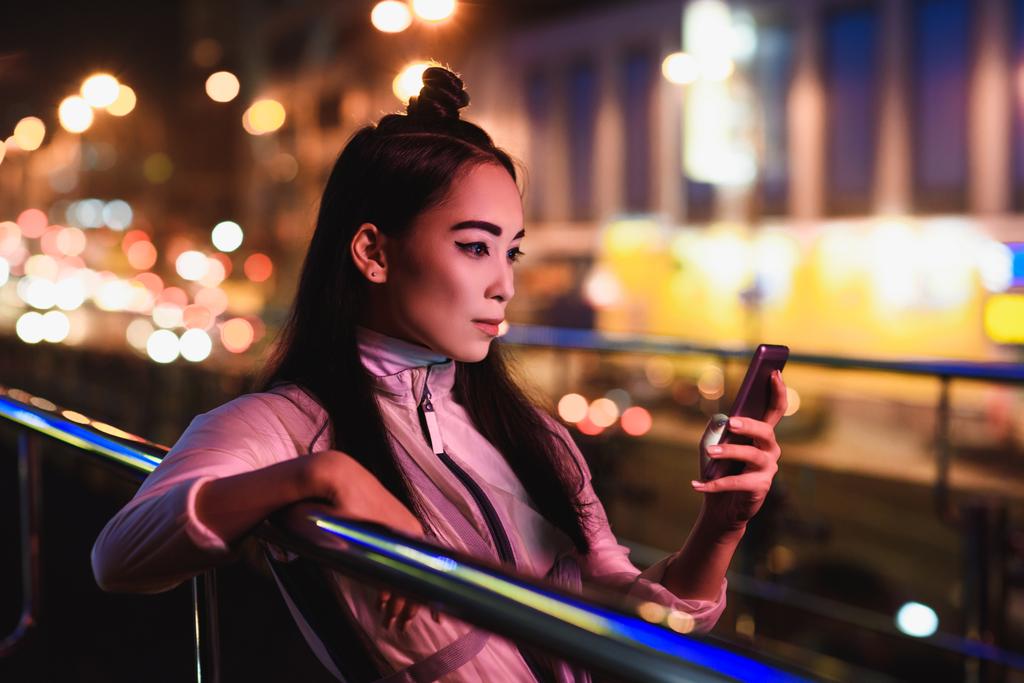 attrayant asiatique fille en utilisant smartphone sur la rue avec néon lumière dans la soirée, ville de concept futur
 - Photo, image