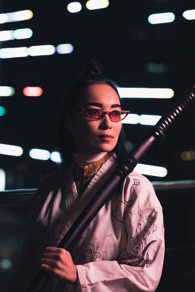 Atrakcyjna dziewczyna azjatyckich w białe kimono trzymając miecz na ulicy z neon światło wieczorem, miasto przyszłości koncepcji - Zdjęcie, obraz