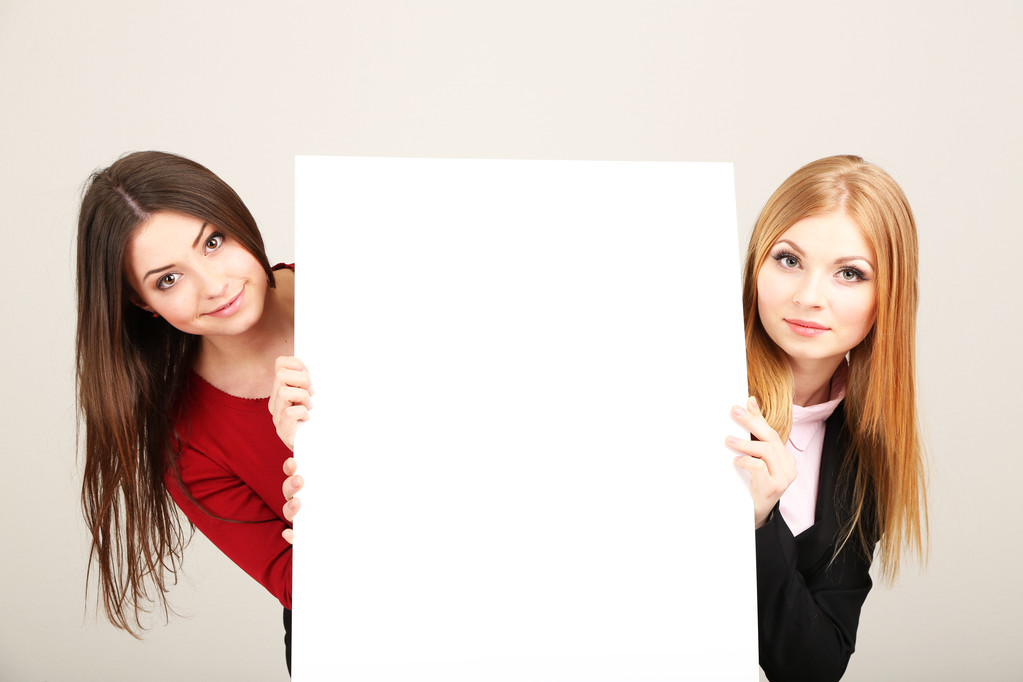 zwei Geschäftsfrauen mit leerem Formular auf grauem Hintergrund - Foto, Bild