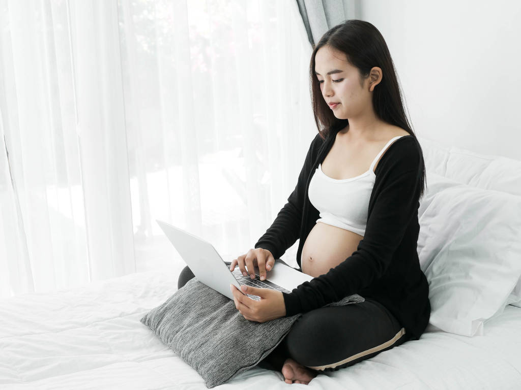 Asijské těhotná žena pomocí přenosného počítače na posteli doma, stylu života - Fotografie, Obrázek