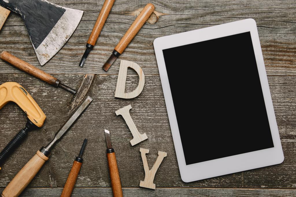 Flat lag met digitale tablet, diy teken en verschillende timmerwerk tools op houten achtergrond - Foto, afbeelding