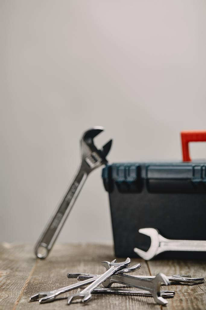 Close up van verschillende tools op houten tafel op grijze achtergrond - Foto, afbeelding