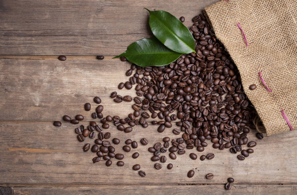 Tableau noir avec grains de café et une tasse de café sur bois brun naturel
 - Photo, image