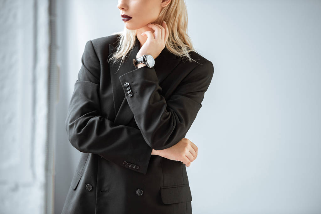 corte vista de jovem mulher em terno preto posando no cinza
 - Foto, Imagem
