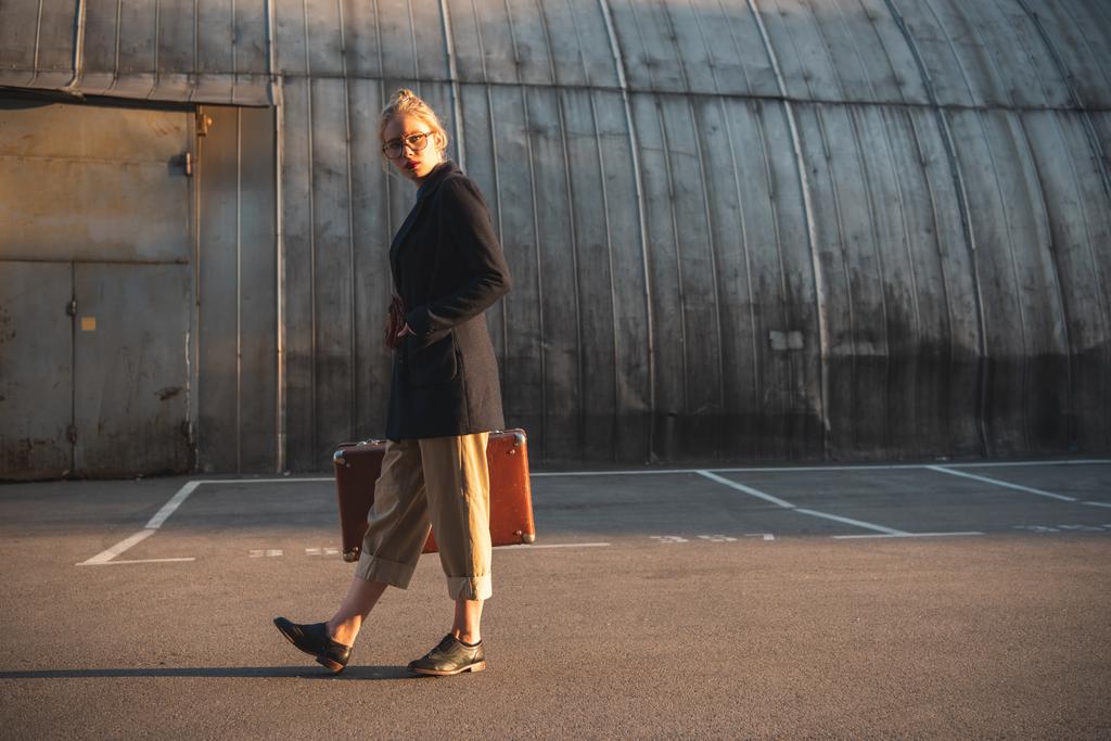 Elegantes Mädchen mit Retro-Koffer auf Stadtparkplatz - Foto, Bild