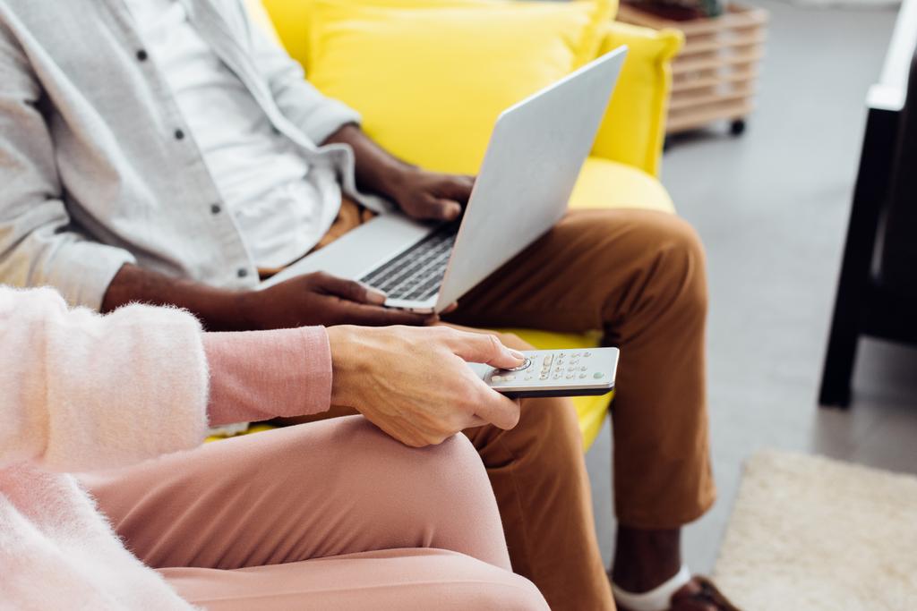 zár megjelöl-ból afrikai amerikai férfi használ laptop míg asszony rámenős gombok, a távirányító - Fotó, kép