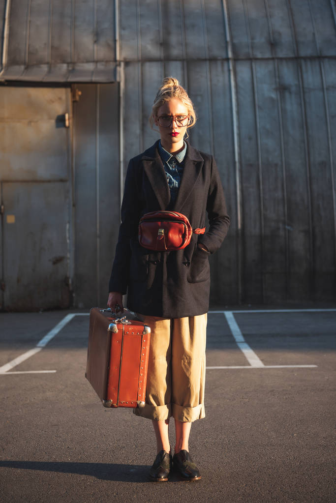 frottir gazdaság vintage bőrönd, a városi parkolás vonzó divatos lány - Fotó, kép