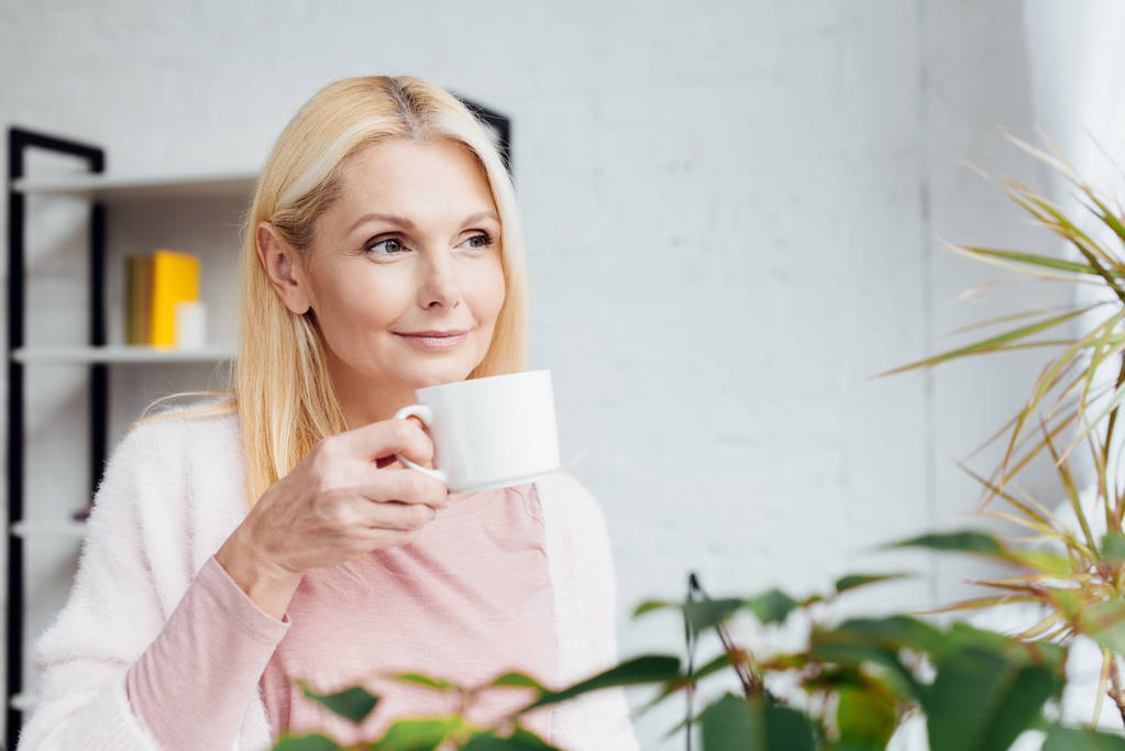 bella donna bionda matura che beve caffè a casa
 - Foto, immagini