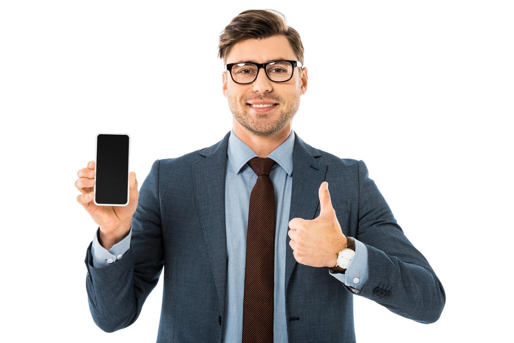 hombre de negocios guapo en traje que muestra la pantalla en blanco en el teléfono inteligente y pulgares hacia arriba aislado en blanco
 - Foto, imagen