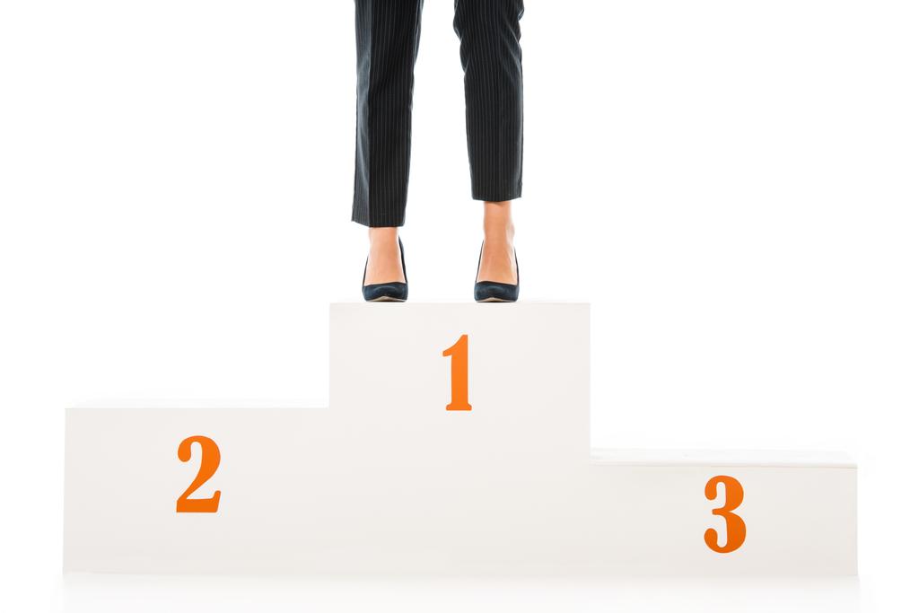 cropped view of businesswoman standing on winners podium isolated on white - Photo, Image