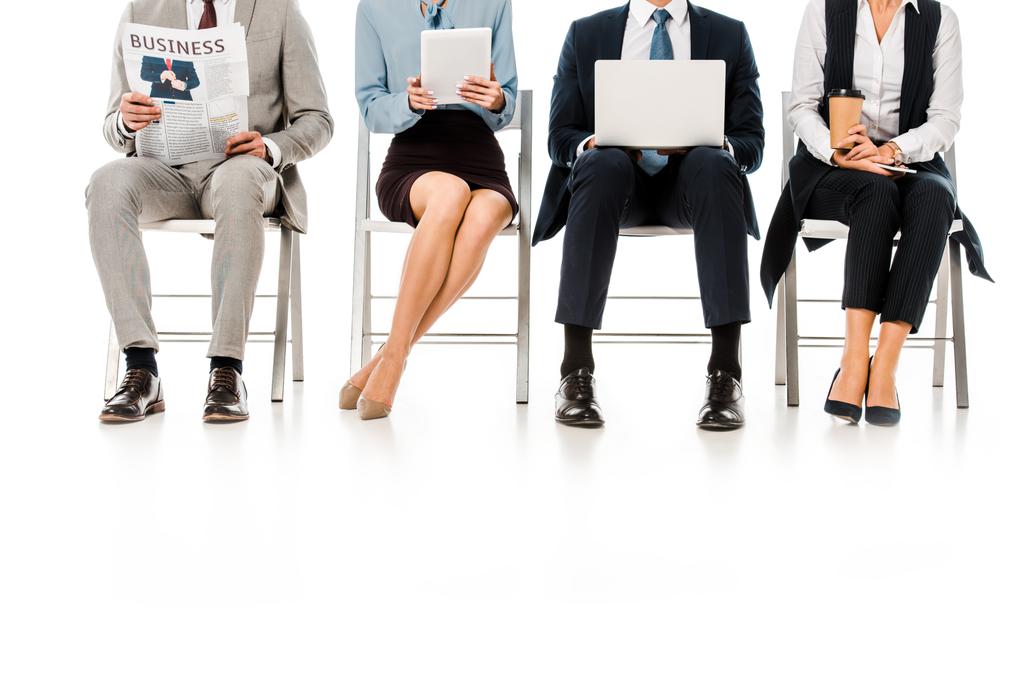 низький вид бізнесменів, що сидять на стільцях з цифровими пристроями, газетами та чашкою кави, ізольовані на білому
 - Фото, зображення