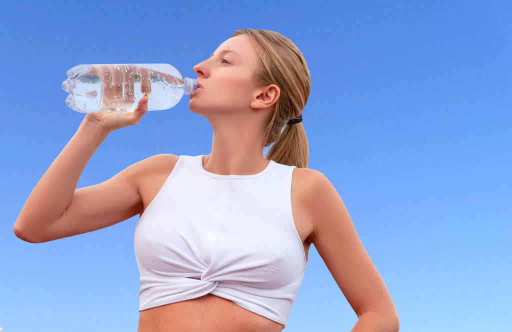 Спортивная женщина пьет воду из бутылки после занятий фитнесом
 - Фото, изображение