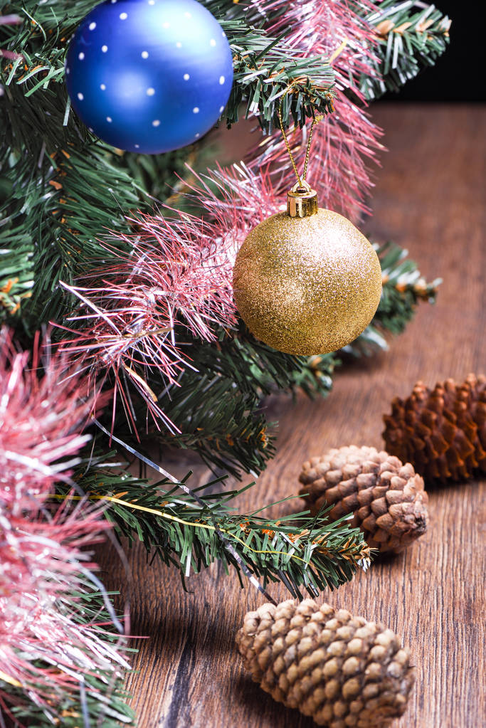 Выборочный фокус. Рождественская елка с игрушками и шишками на деревянном столе. Сельский стиль
 - Фото, изображение