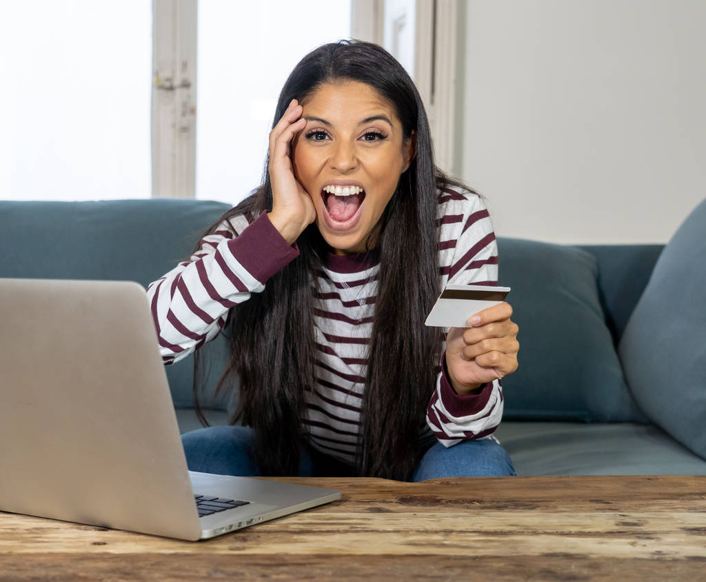 Vonzó fiatal latin nő gazdaság hitelkártya, és segítségével a laptop számítógép vásárlás az interneten otthon, a vásárlás a vonal üzleti és technológiai digitális marketing alkalmi életmód fogalma. - Fotó, kép