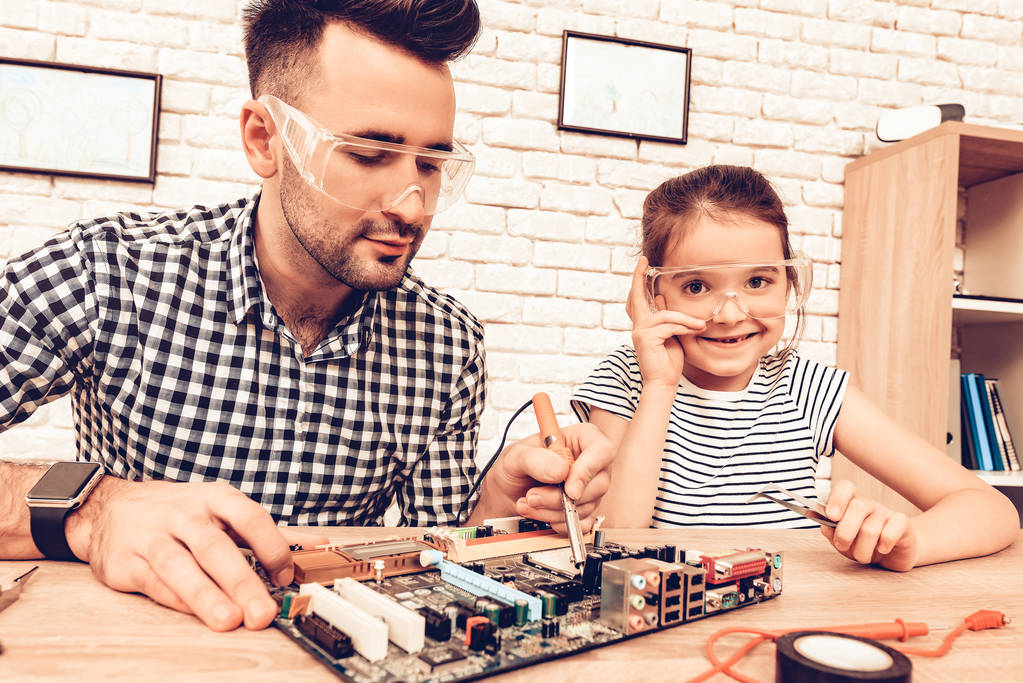 Man and Girl with Tool. Father and Daughter on Sofa. Spend Time Together. Father's day. White Interior. Review Device. Spare Parts on Table. Measure with Tape. Father Master and Daughter in Glasses. - Photo, Image