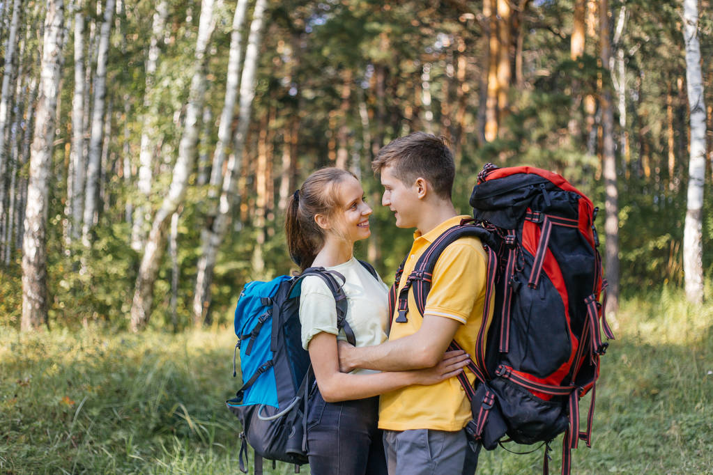 couple of tourists with backpacks hiking in a forest - Photo, Image