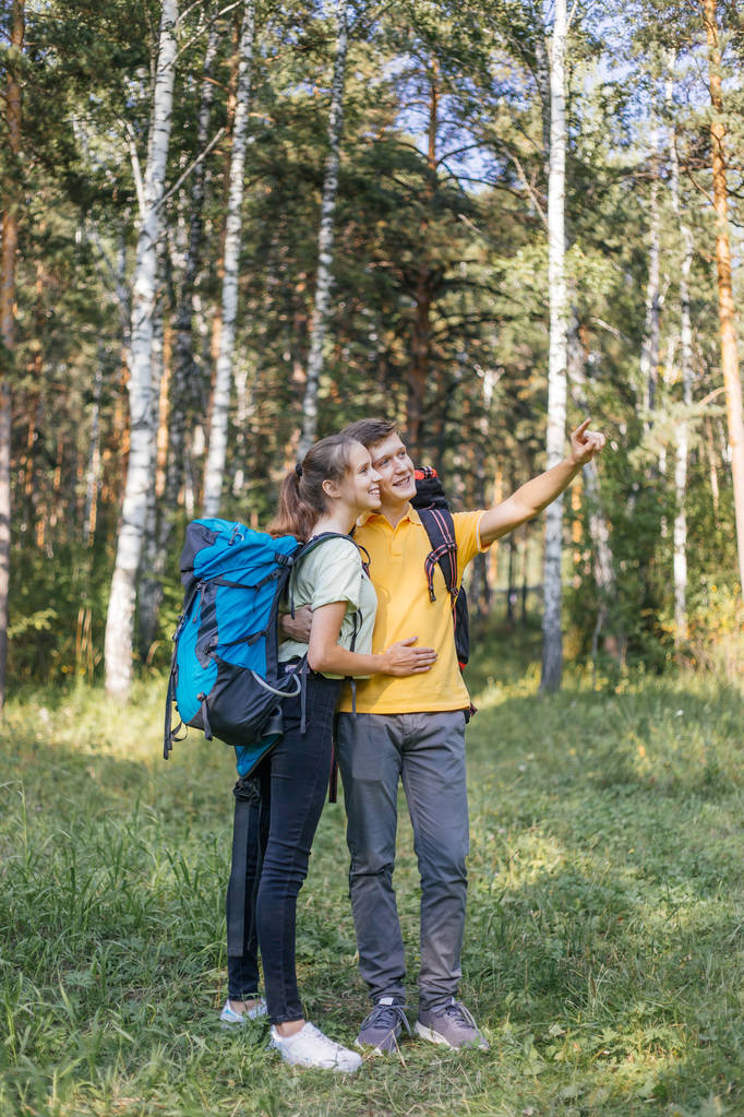 森のハイキングのバックパックで観光客のカップル - 写真・画像