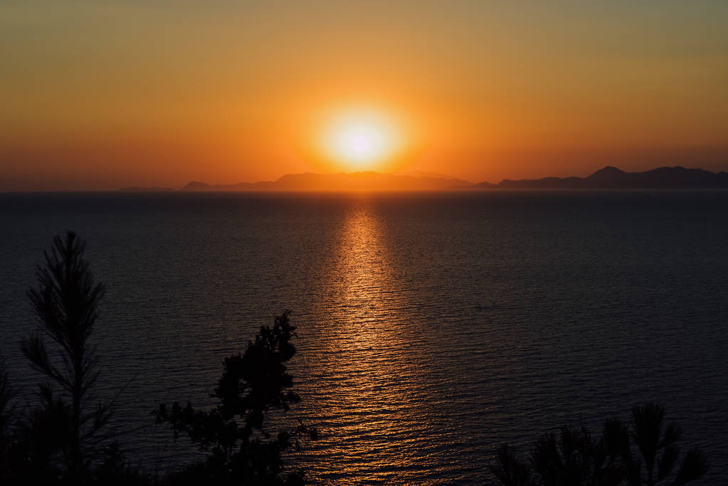 RODI, GRECIA - CIRCA GIUGNO 2018: Mar Egeo al tramonto sul bordo occidentale dell'isola di Rodi, Grecia
. - Foto, immagini
