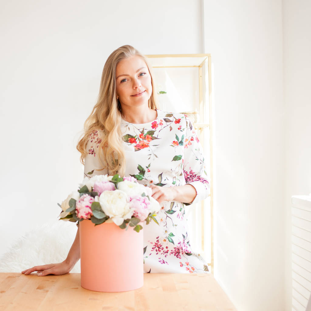 Onnellinen blondi nainen modernissa toimistossa kukkia hattulaatikossa. Kukkakimppu pioneja
. - Valokuva, kuva