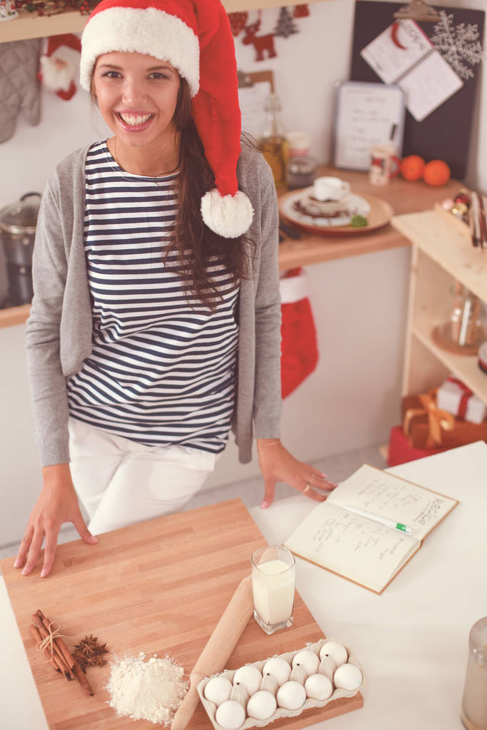 Woman making christmas cookies in the kitchen - Photo, Image