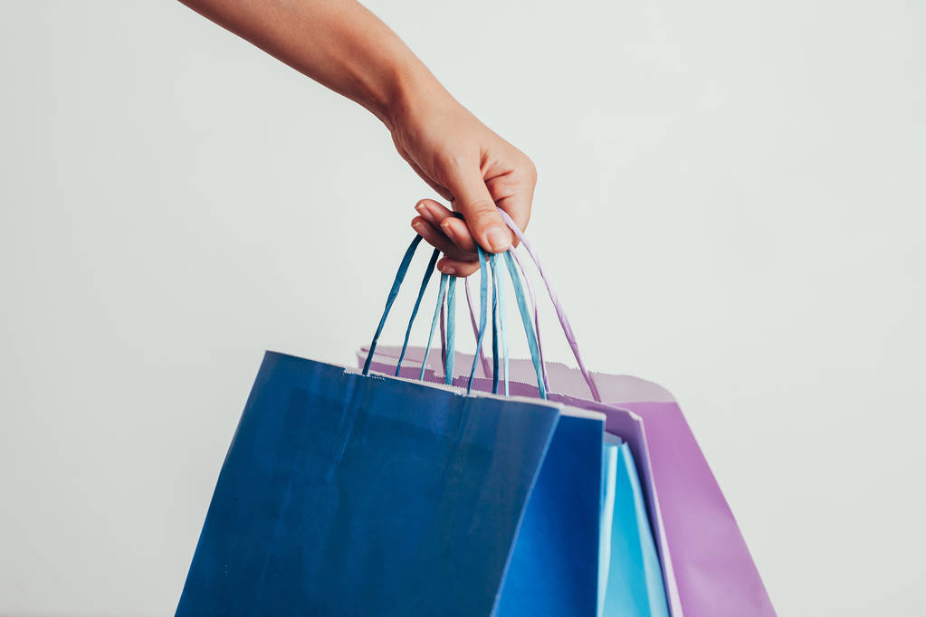 people, sale, consumerism, advertisement and black friday concept - close up of hand holding shopping bags - Photo, Image