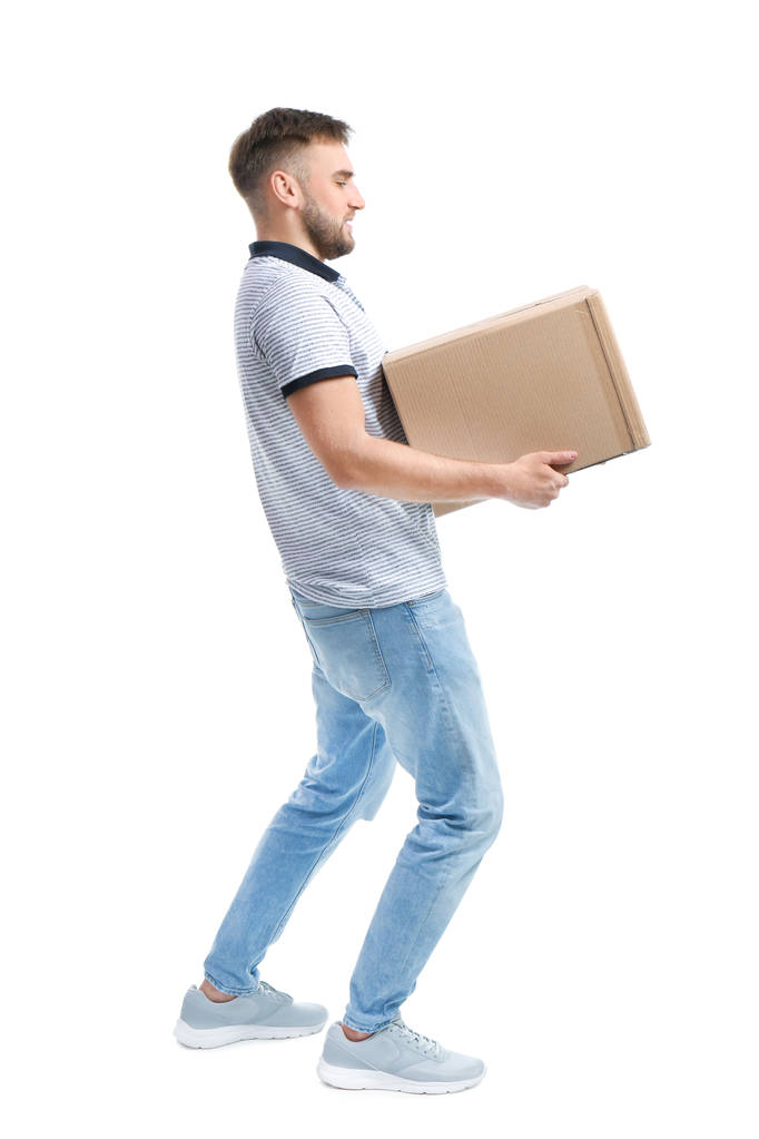 Full length portrait of young man carrying carton box on white background. Posture concept - Photo, Image