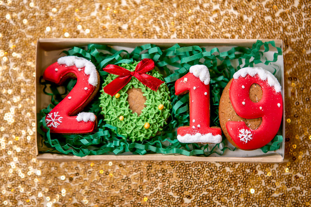 Cookie sotto forma di numeri 2019 in scatola di cartone su sfondo dorato. Dolci natalizi. Tema di Capodanno e Natale. L'umore festivo. Lato piatto, Vista dall'alto
. - Foto, immagini