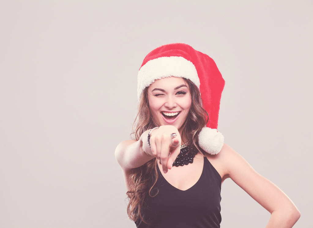 Retrato de uma mulher bonita usando um chapéu de Papai Noel sorrindo
. - Foto, Imagem