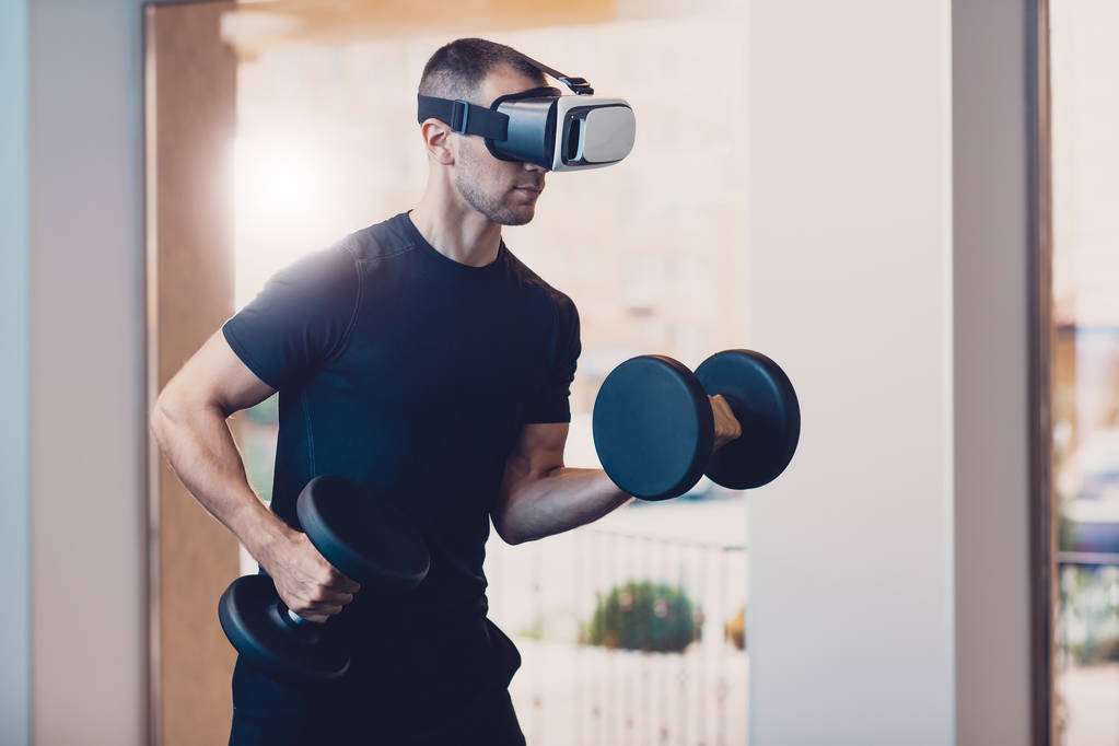 Uomo che indossa occhiali di realtà virtuale con manubri
 - Foto, immagini