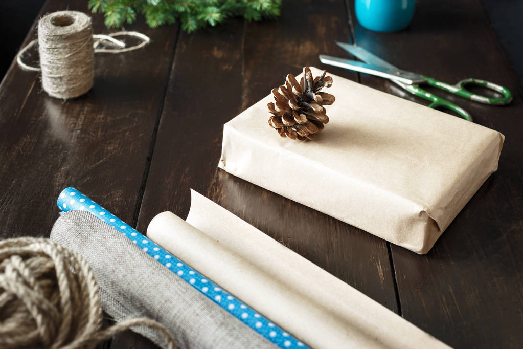 Boże Narodzenie Zawijanie pudełeczka na drewnianym stole. Rustykalne Christmas background. Zawijanie przedstawia tło - Zdjęcie, obraz