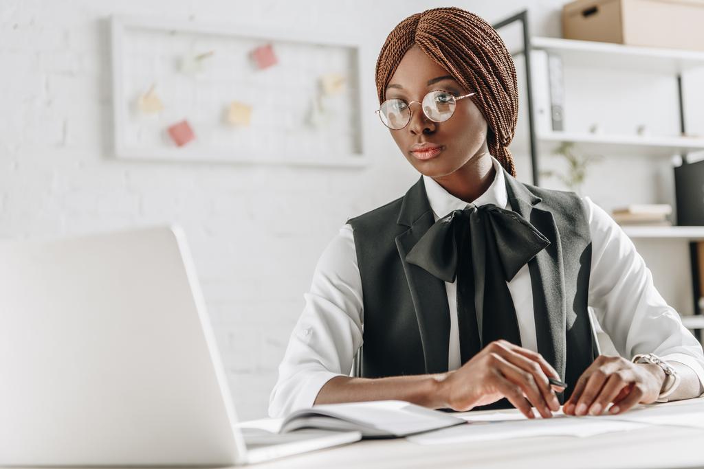 bilgisayar masası oturma ve çalışma office bardaklarda çekici Afro-Amerikan yetişkin iş kadını - Fotoğraf, Görsel