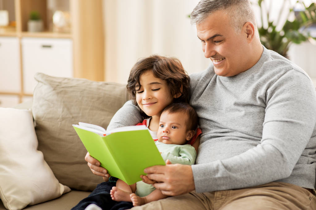 onnellinen isä poikien kanssa lukeminen kirja kotona
 - Valokuva, kuva