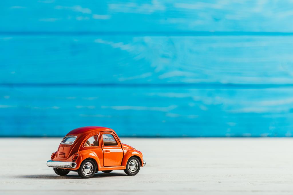 mavi ahşap arka plan üzerinde kırmızı oyuncak araba yakın çekim vurdu - Fotoğraf, Görsel