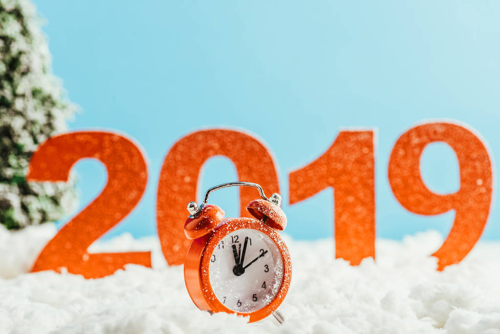 big red 2019 numbers with vintage alarm clock standing on snow on blue background, new year concept - Photo, Image