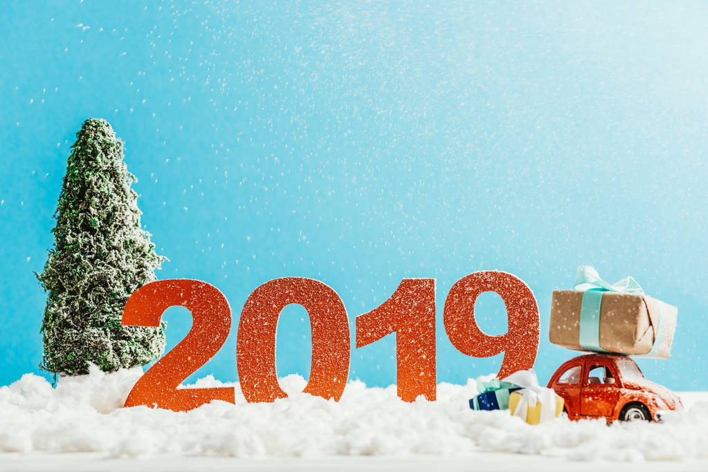 große rote Zahlen 2019 mit Spielzeugauto, Geschenken und Weihnachtsbaum auf Schnee für Neujahr - Foto, Bild